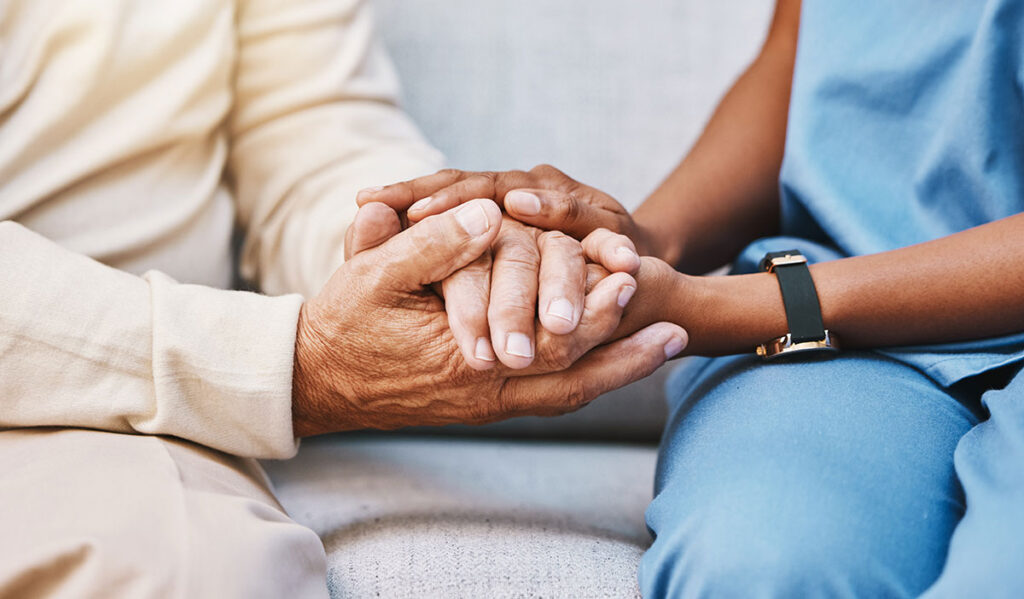 healthcare worker holding patients hand